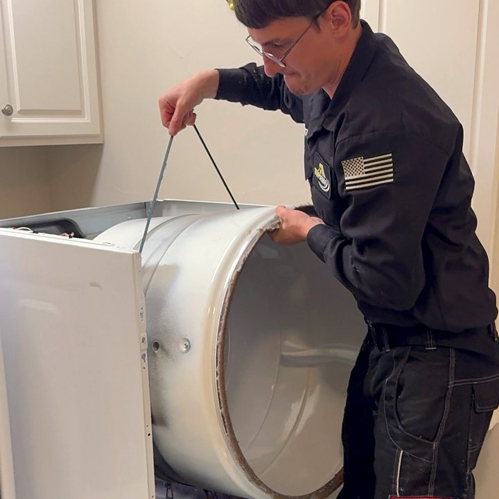 Technician performing dryer maintenance
